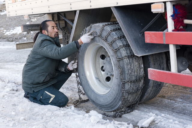 冰雪路上，其美多吉给汽车加挂链条。省委组织部供图