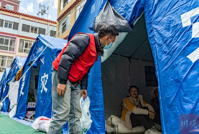 刘凯强在安置点发放矿泉水。洛绒尼玛 摄