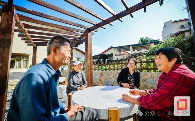 村干部和村民在凉亭下交流