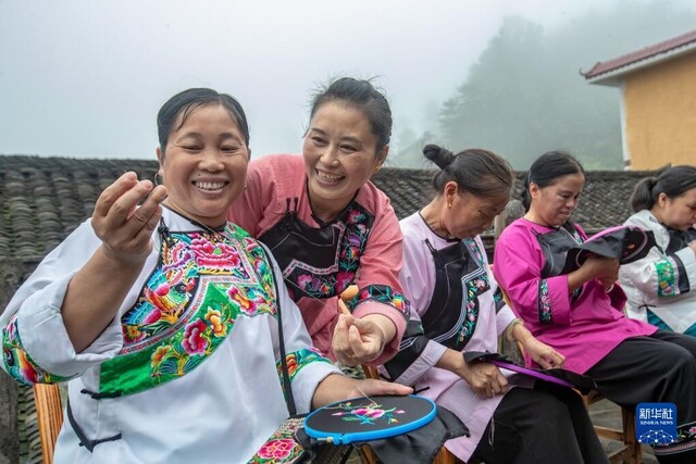 在湖南省湘西土家族苗族自治州花垣县十八洞村，村民在讨论苗绣制作（2020年7月16日摄）。新华社发（石林荣 摄）
