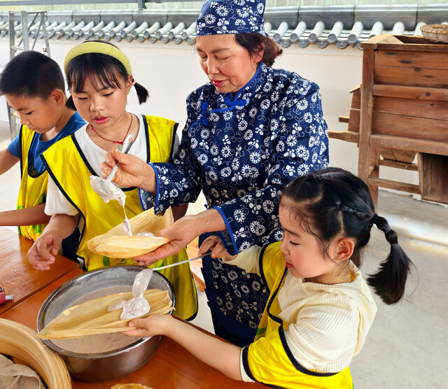 孩子们在认真学习包冻粑技术。.jpg