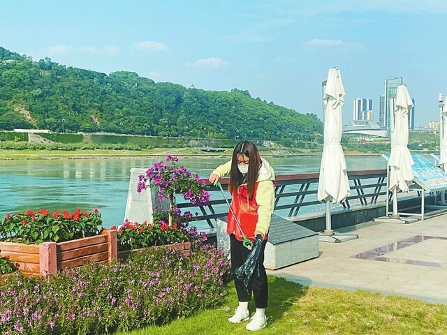长江公园内，三江志愿者管护队队员在清理垃圾。 四川日报全媒体记者 宁宁 摄