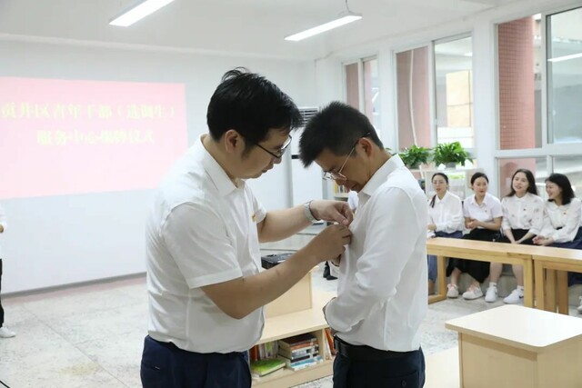 ▲张腾为青年干部代表颁发胸章