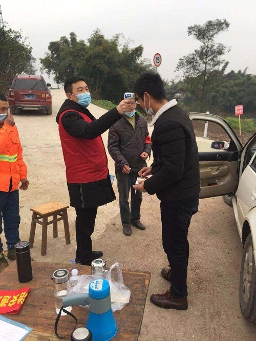 镇代表测量来往群众体温.jpg